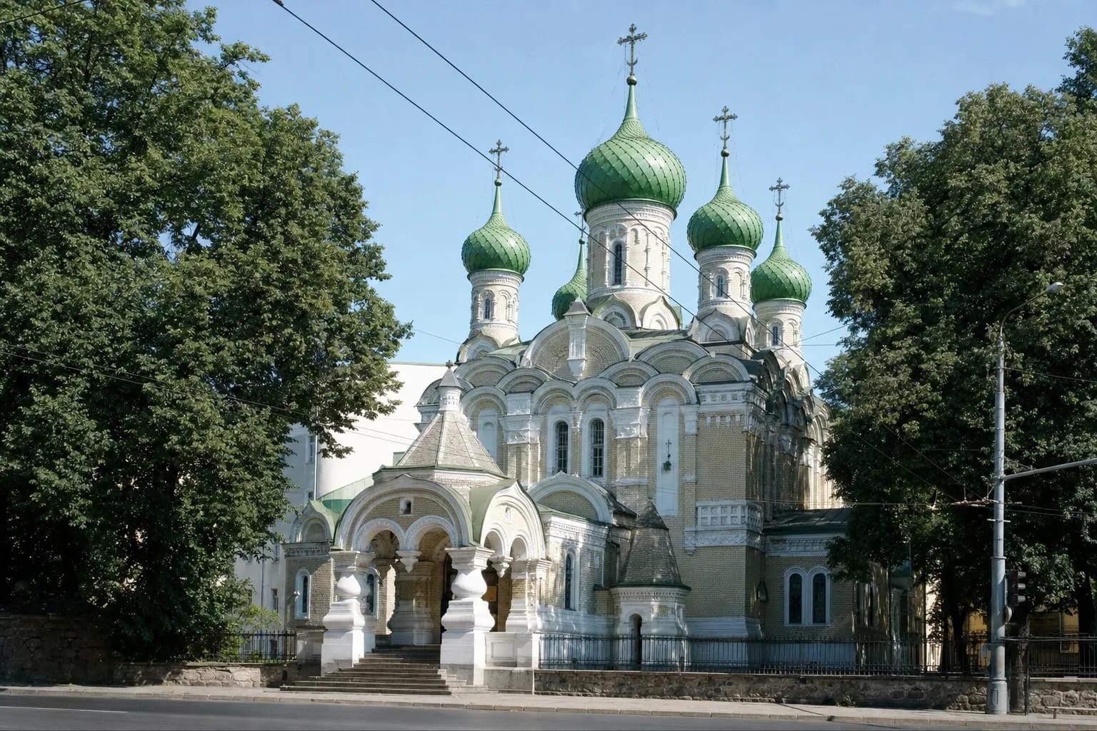 Pale façade of the Church of Saints Constantine and Michael in Vilnius with white ornament and five green onion domes