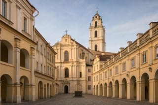 Historic Vilnius University courtyard with arcades, St Johns' Church, and bell tower