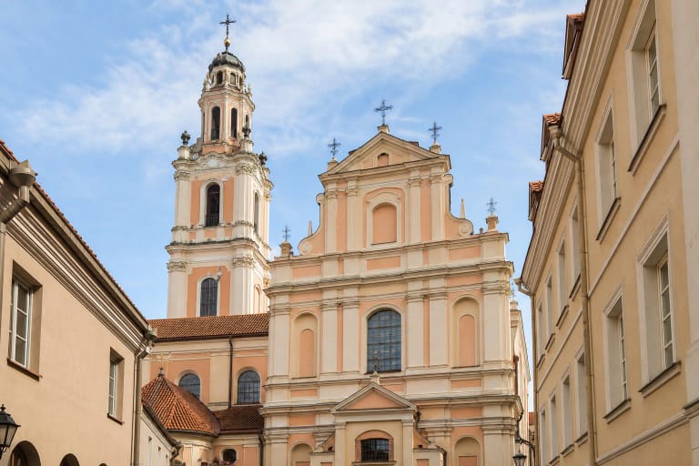 Early Baroque facade and ornate high bell tower of All Saints Church on Rūdninkų Street in Vilnius
