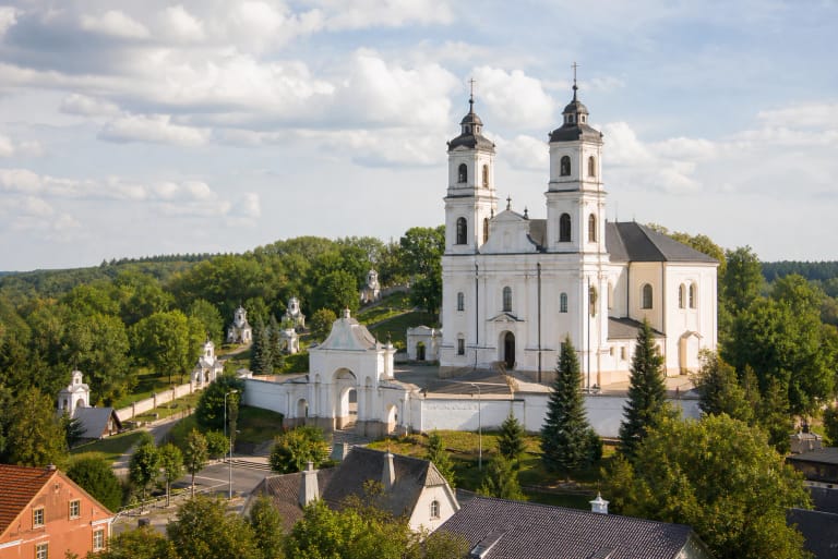Žemaičių Kalvarijos balta dvibokštė bazilika su šalia esančiomis Kalvarijos kalnų koplyčiomis ir Žemaitijos žaluma