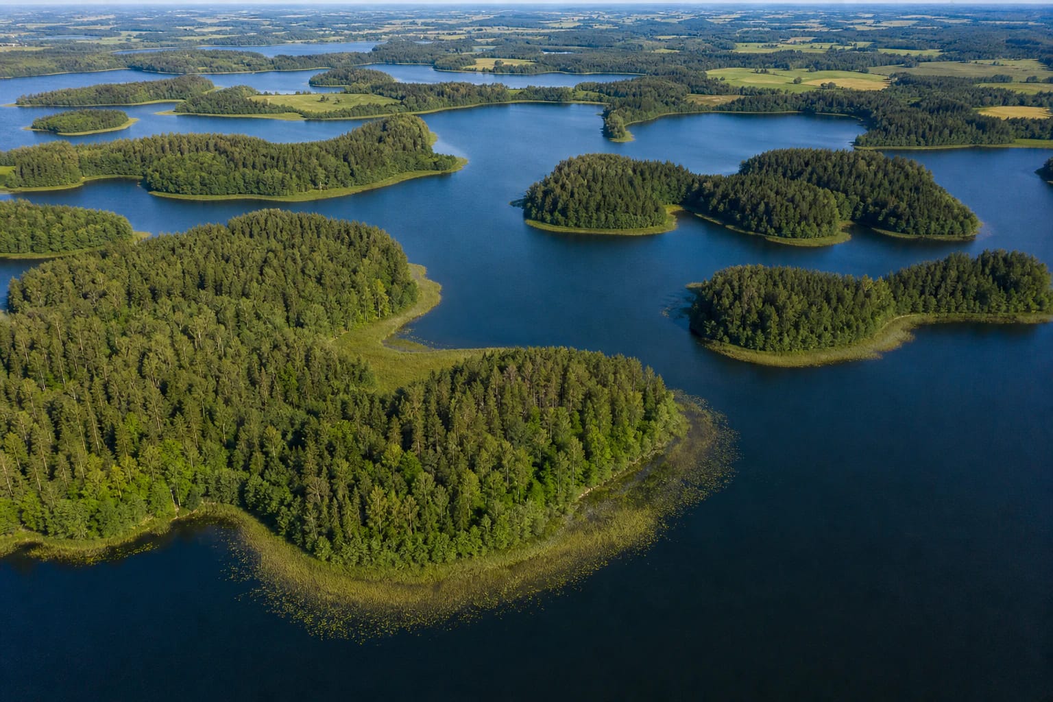 Lake Plateliai panorama in Žemaitija National Park with wooded islands, peninsulas, bays, and rural fields