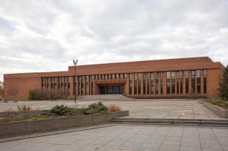 Red-brick modernist facade of Žvejų Rūmai and its broad plaza on Taikos Avenue in Klaipėda